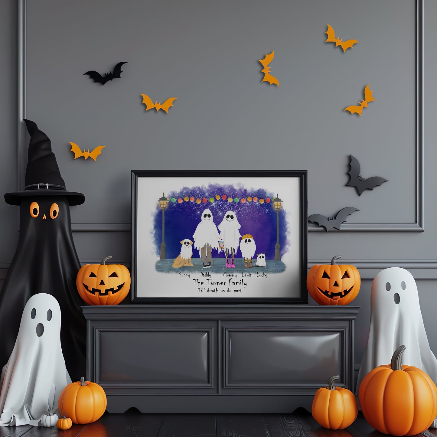 Halloween-themed room with framed family portrait, ghosts, pumpkins, and decorative bats on a gray wall.