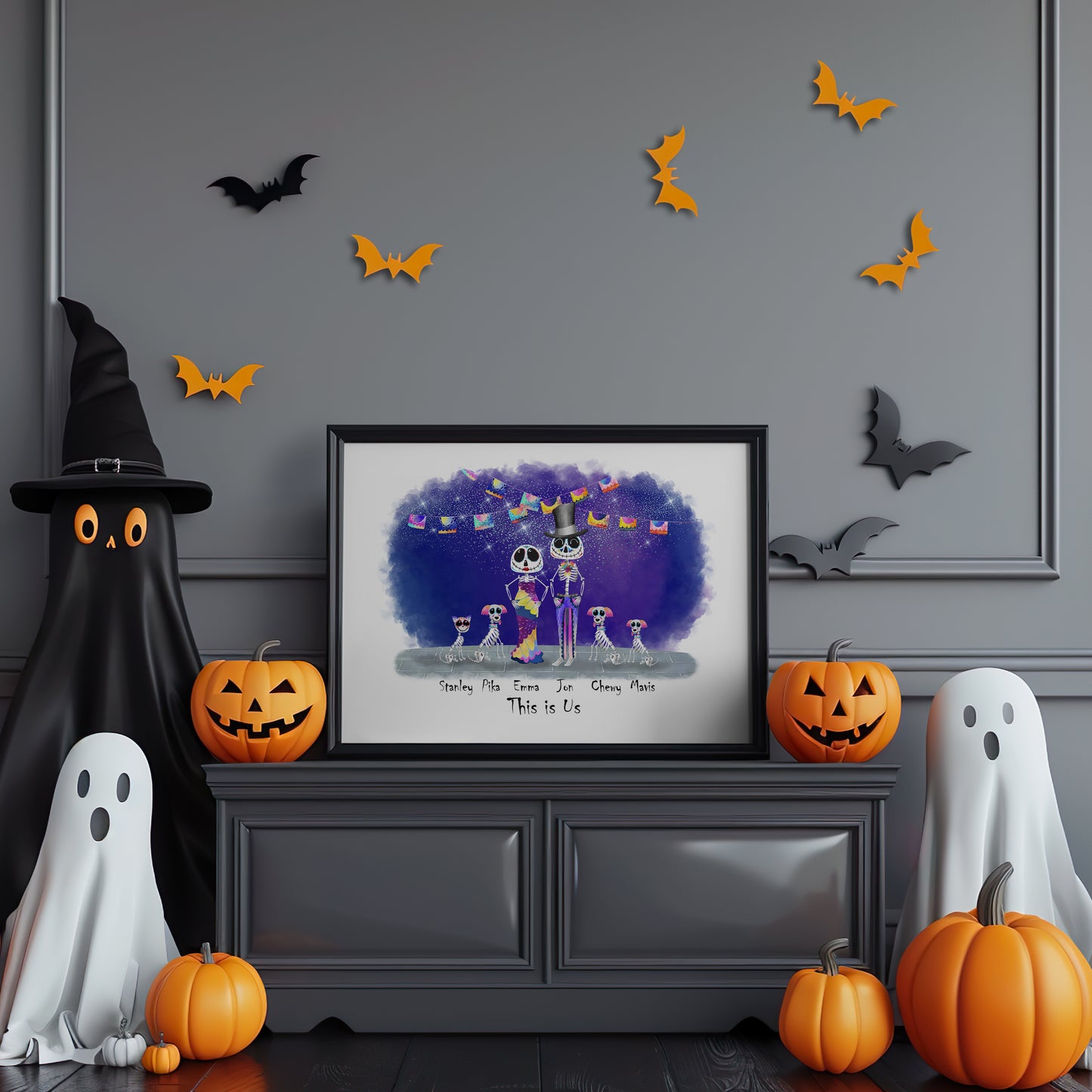 Halloween-themed room with framed artwork, pumpkins, ghosts, and bats on a gray wall.