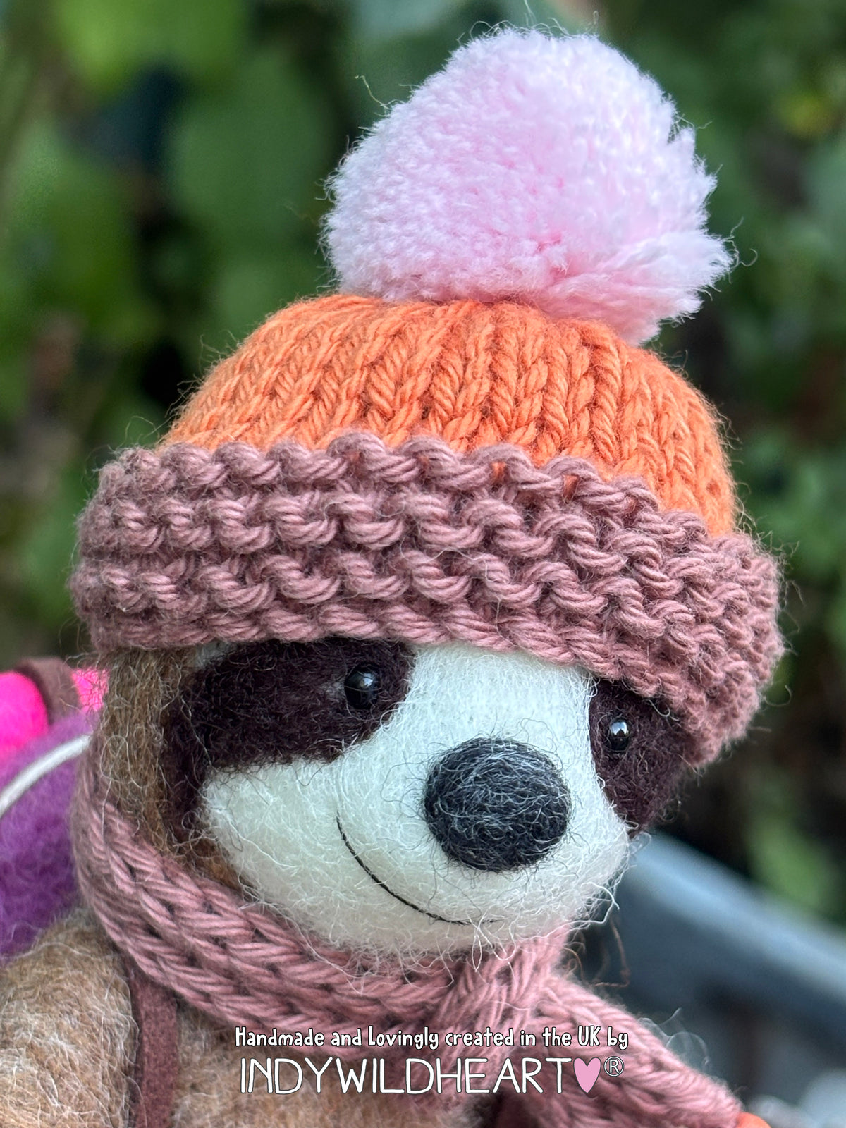 Needle Felted Brown Sloth sitting, wearing a knitted brown & orange hat with a pink bobble.  