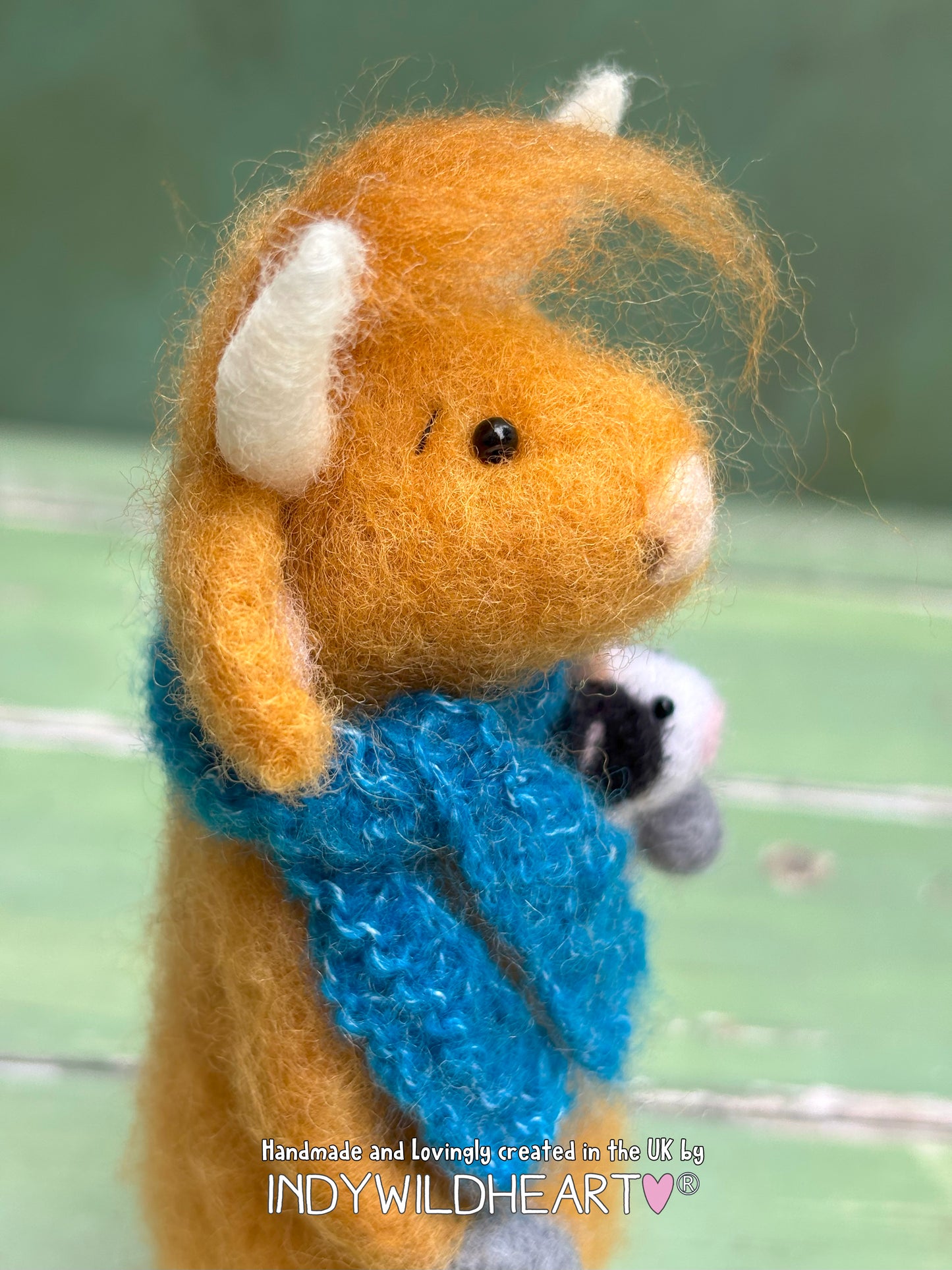 Handmade felted animal highland cow with a blue scarf. needle felt collectible.