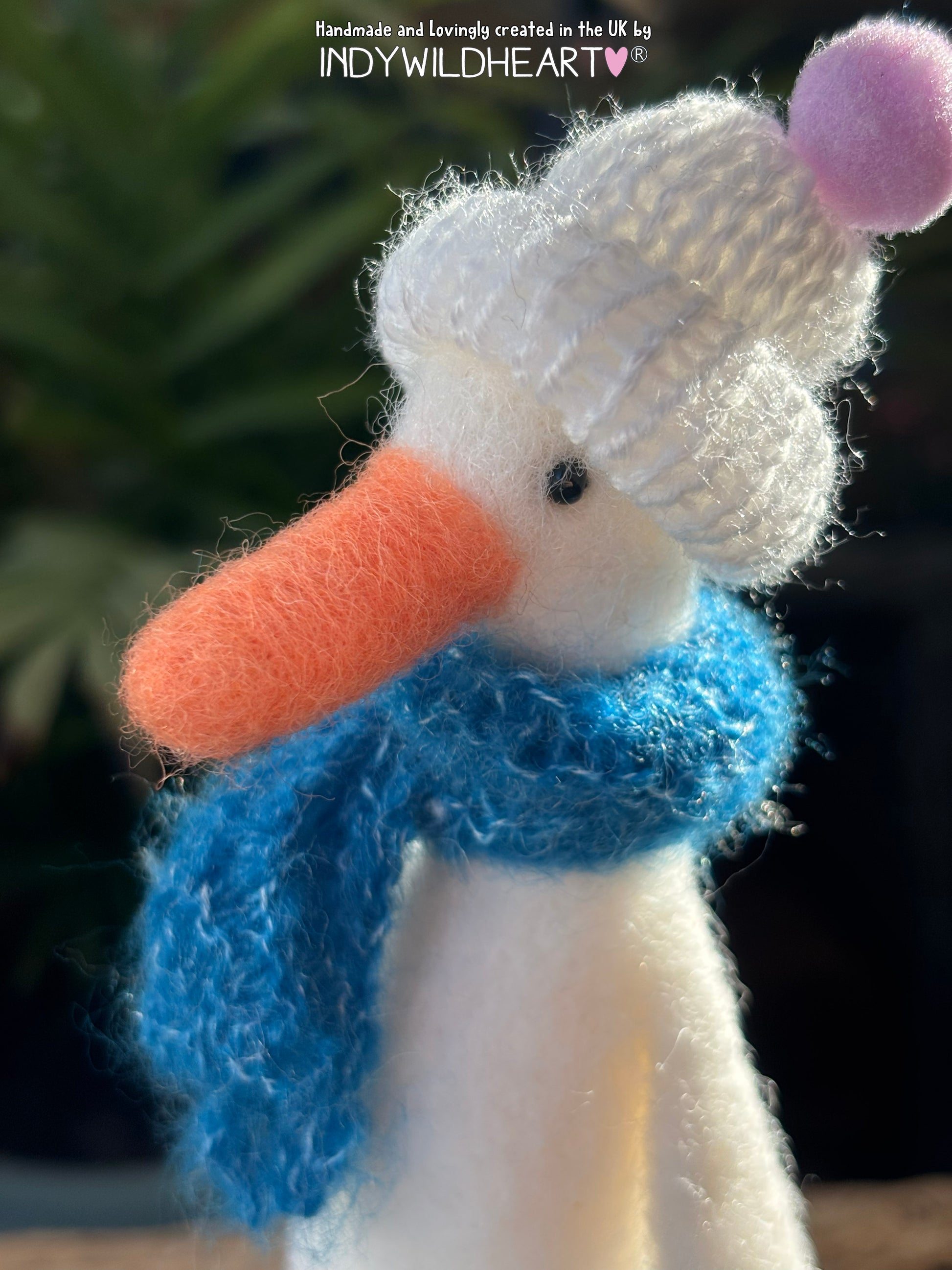 needle felted white duck with a blue scarf and white bobble hat, created by Indywildheart.